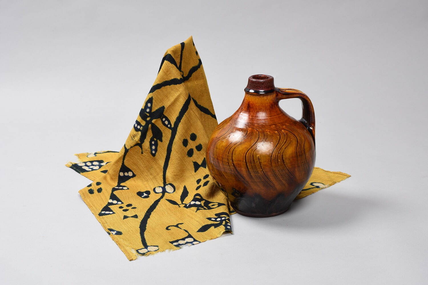 (左) 柚木沙弥郎 《注染魚文布》 1950年代 個人蔵
(右) 舩木研兒 《鉄鉛釉手付壺》 1981年頃 島根県立美術館蔵