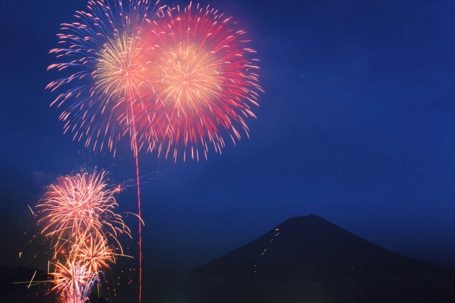 富士山｜「富士山・河口湖山開きまつり花火大会」山梨・大池公園で、富士山を背景に見る打ち上げ花火
