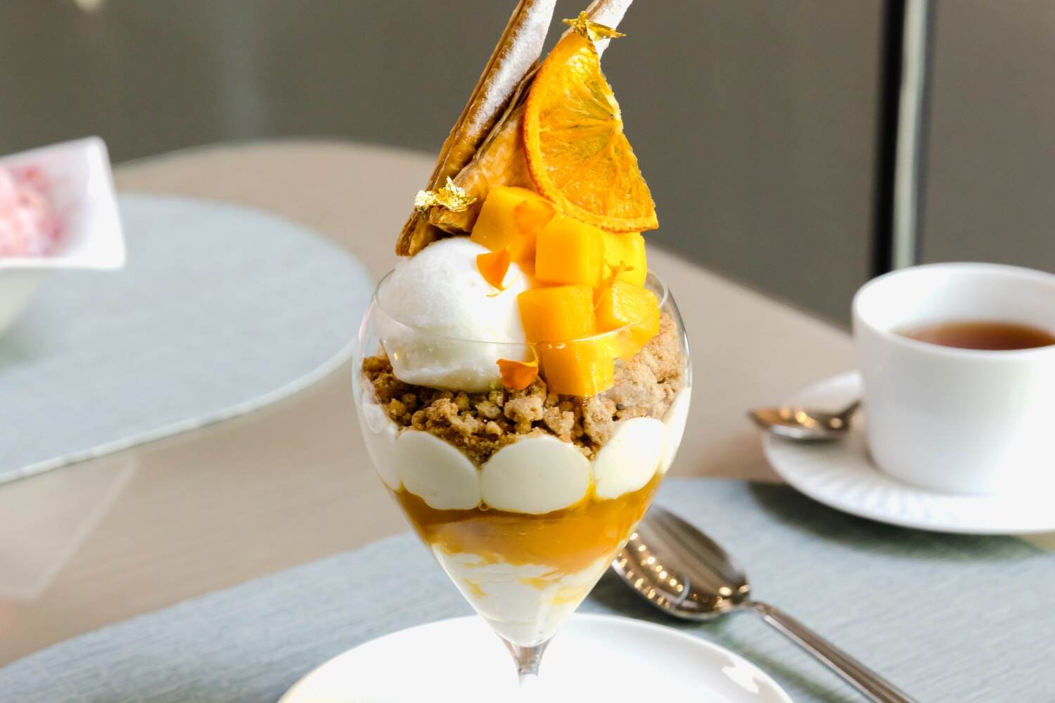 アルマーニ / カフェ 表参道の夏限定マンゴーパフェ、ミルキーな杏仁ソルベ×黒糖クランブルをオン