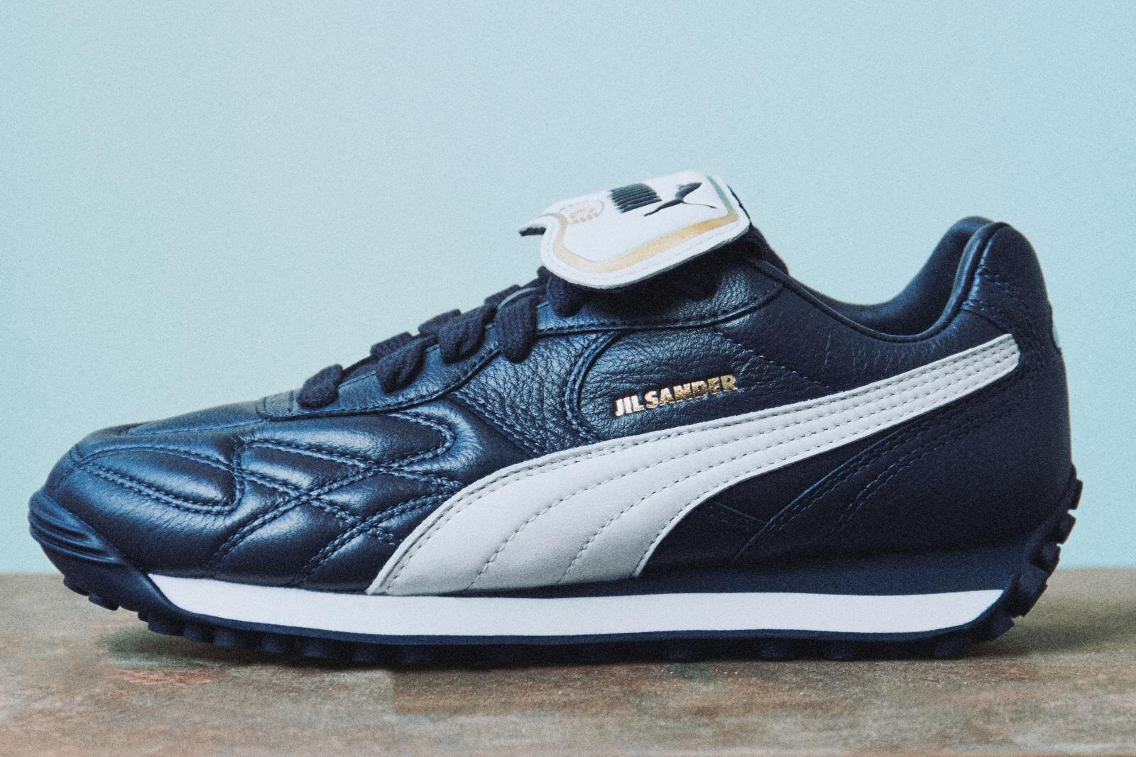 ジル サンダー×プーマのスニーカー、金のロゴ入り上質レザーアッパー