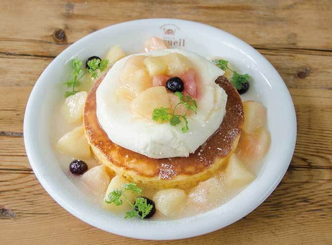 カフェ アクイーユの「天使のクリーム 桃のレアチーズパンケーキ」桃の果肉たっぷりのソースをかけて | 写真