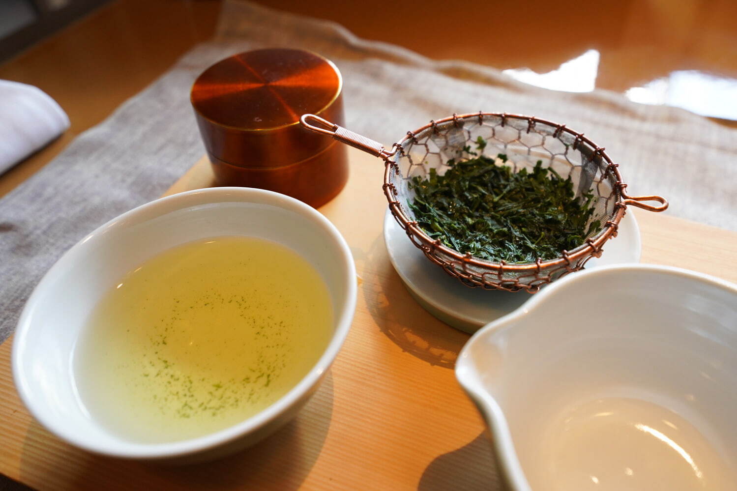 ティートレイは「中川木工芸」、青磁のティーポットと煎茶碗は「茶陶朝日焼」、真鍮の茶筒は「開化堂」、インフューザーは「金網つじ」のもの。